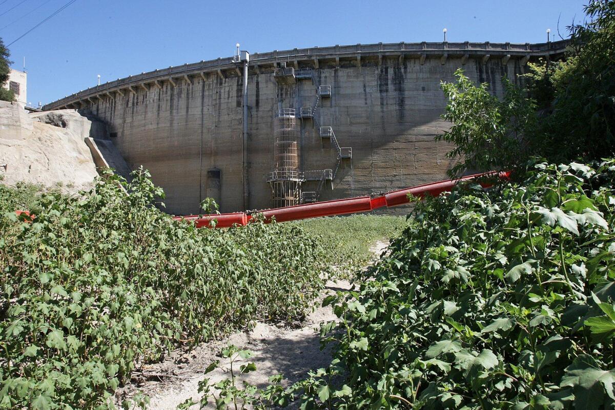 A long boom spanning the holding area at Devil's Gate Dam in the Hahamongna Watershed hangs in the air above a dry floor in this 2014 file photo.