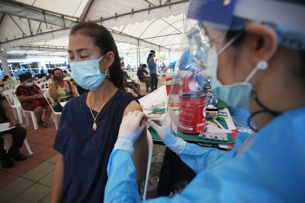 FILE - In this Tuesday, May 4, 2021, file photo, a health worker administers a dose of the Sinovac COVID-19 vaccine to residents of the Klong Toey area, a neighborhood currently having a spike in coronavirus cases, in Bangkok, Thailand. Thailand sought Thursday, may 6, 2021, to assure its foreign residents that they can get COVID-19 vaccinations, countering comments by some officials suggesting they would be at the end of the line for inoculations. (AP Photo/Anuthep Cheysakron)