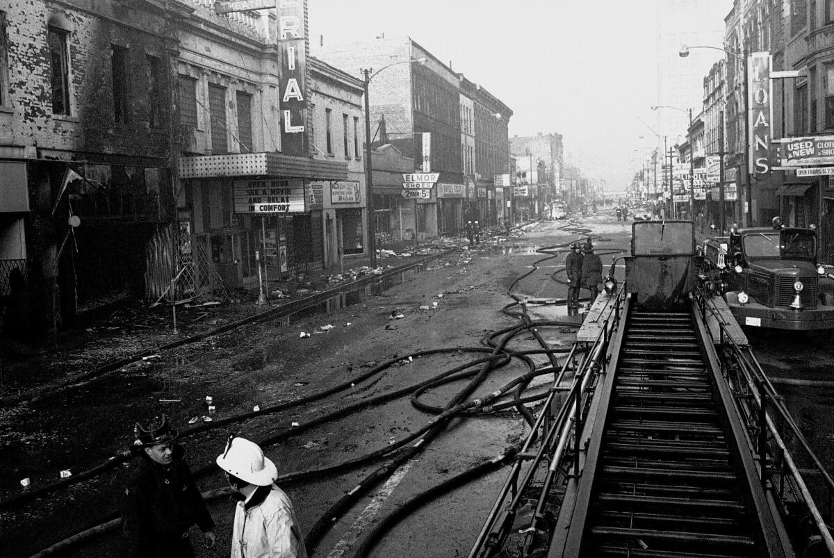 Firemen hose down smoldering embers on West Madison Street in Chicago on April 6, 1968.