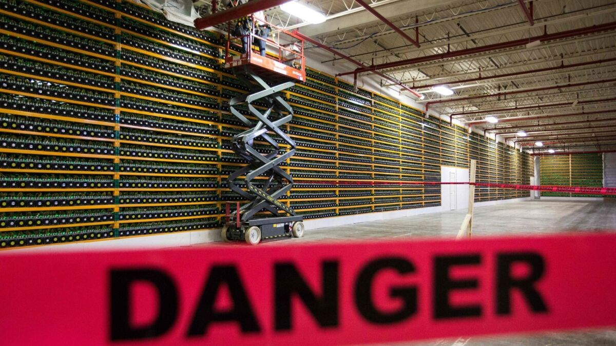 Construction crew works on computers at a bitcoin mining firm in Quebec. How long will it be worth their while?