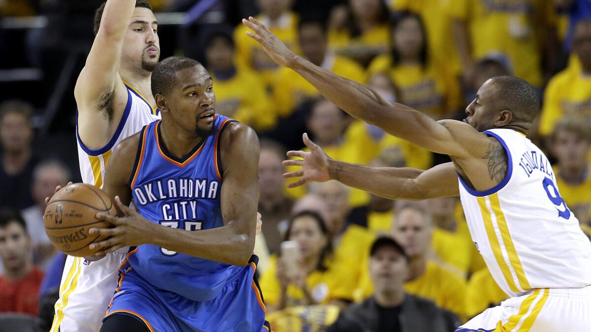Kevin Durant is trapped by Warriors guard Klay Thompson and forward Andre Iguodala (9) during Game 2 of their playoff series in May.