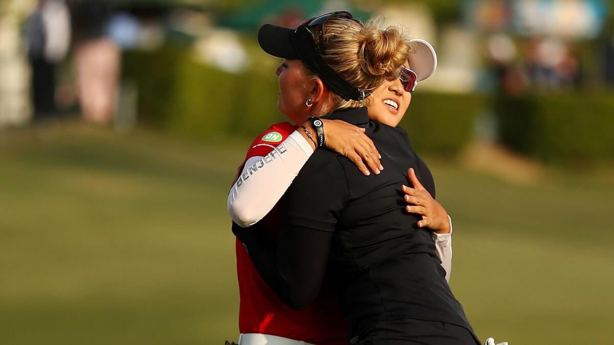 Minjee Lee and Nanna Koerstz Madsen hug after the completion of the third round at Wilshire Country Club.