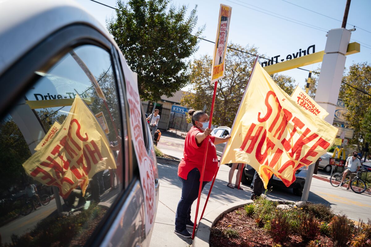 Rosa Vargas, of San Jose, stands in the drive-thru line during a strike to protect essential workers at McDonald's