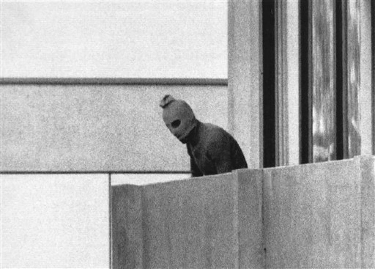FILE - In this Sept. 5, 1972, file photo, a member of the Arab Commando group which seized members of the Israeli Olympic Team at their quarters at the Munich Olympic Village appears with a hood over his face on the balcony of the village building where the commandos held several members of the Israeli team hostage. (AP Photo/Kurt Strumpf, File)