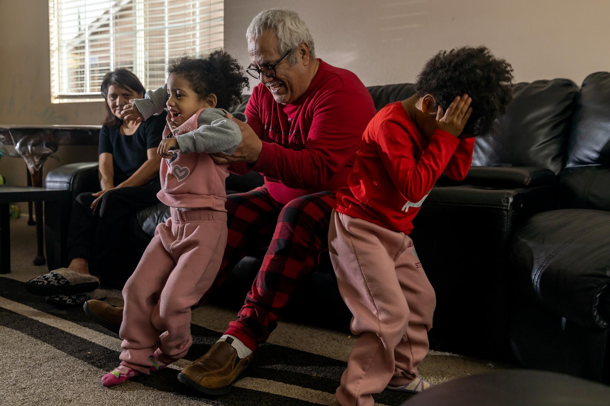 A grandfather plays with his granddaughters