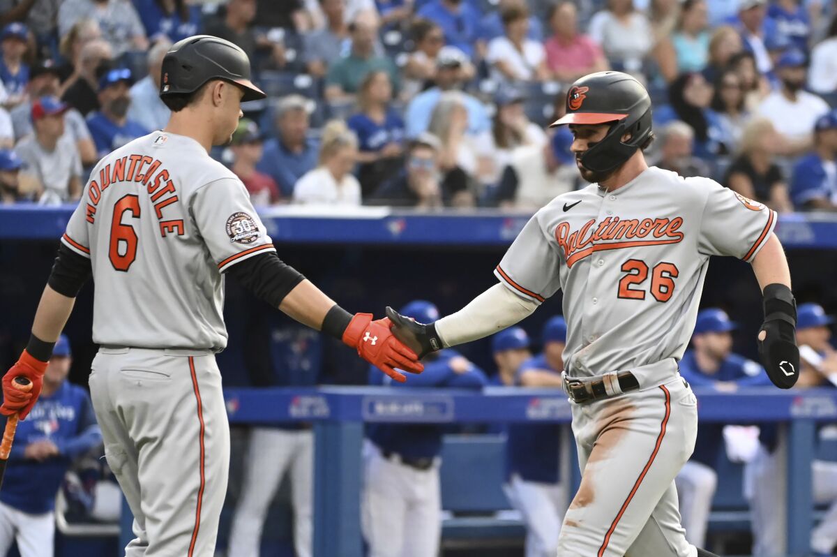 Baltimore Orioles' Ryan McKenna, right, celebrates with Ryan Mountcastle after scoring against the Toronto Blue Jays during the first inning of a baseball game Monday, Aug. 15, 2022, in Toronto. (Jon Blacker/The Canadian Press via AP)
