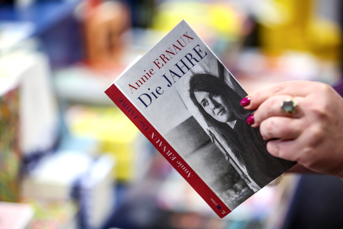 A woman holds the book "The Years" by Annie Ernaux in her hands in a bookstore, in Leipzig, Germany, Thursday, Oct. 6, 2022.