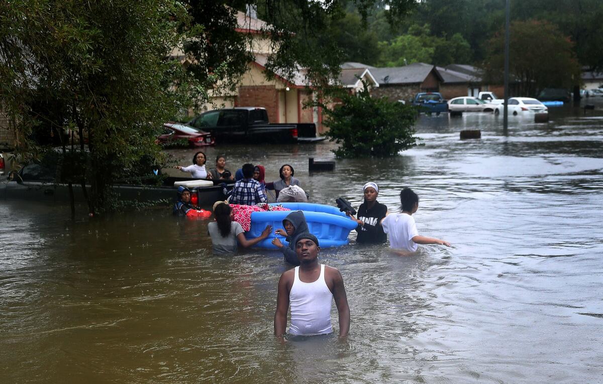 People wade through a flooded street in Houston. (Joe Raedle / Getty Images)