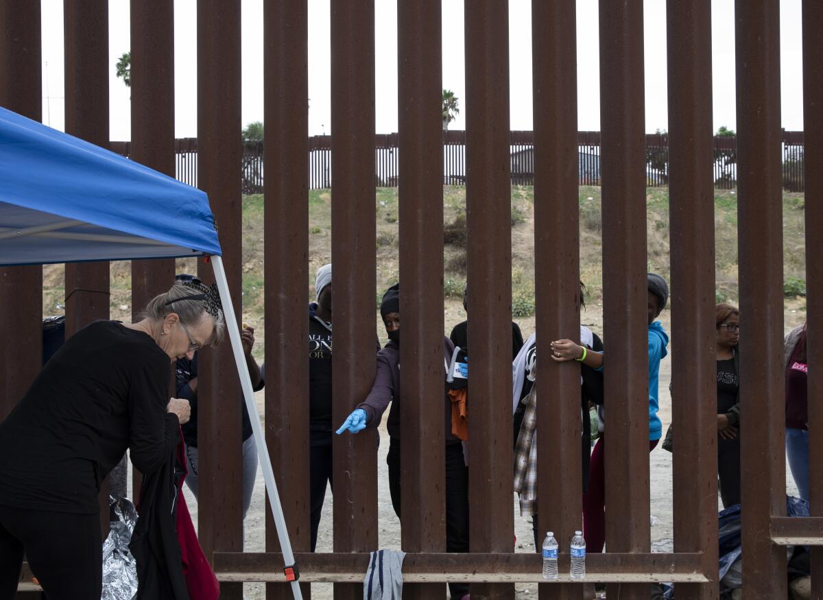 Voluntarios entregan ropa a unas 30 mujeres que esperan entre las dos vallaa