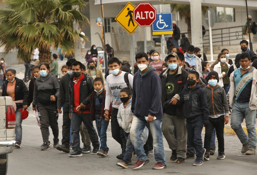 Men, women and children walk on a street in Reynoso, Mexico.