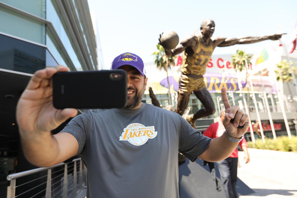 Abdel Assy, a 36-year-old from Canada, takes a selfie in front of the Magic Johnson statue at Staples Center on Monday.