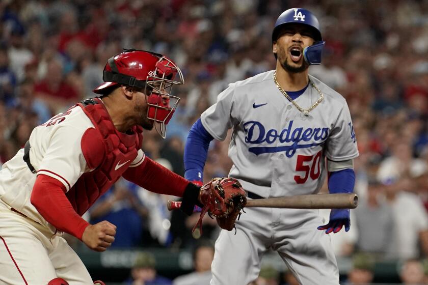 St. Louis Cardinals catcher Willson Contreras, left, celebrates as Los Angeles Dodgers' Mookie Betts reacts.