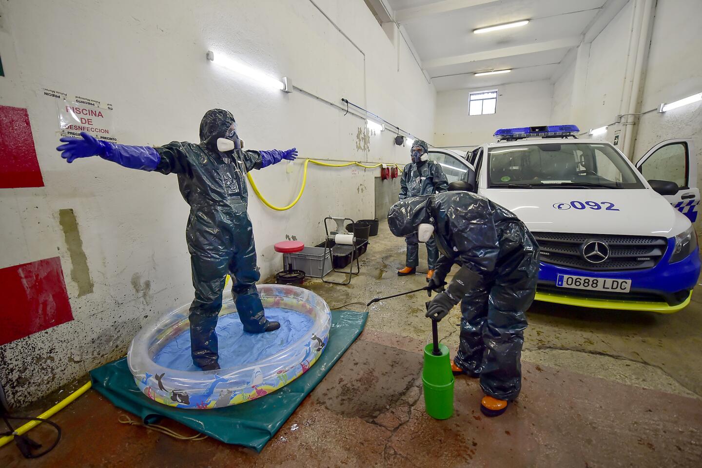 Spain: Volunteer workers of Search and Rescue (SAR) with special equipment disinfect a volunteer after disinfecting a police car at a local police station to prevent the spread of coronavirus in northern Spain.