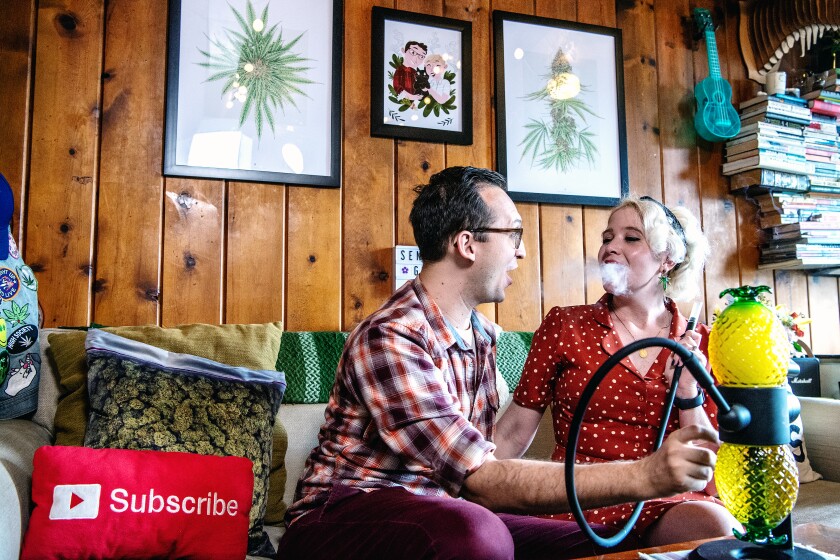 Two people sitting on a couch smoking