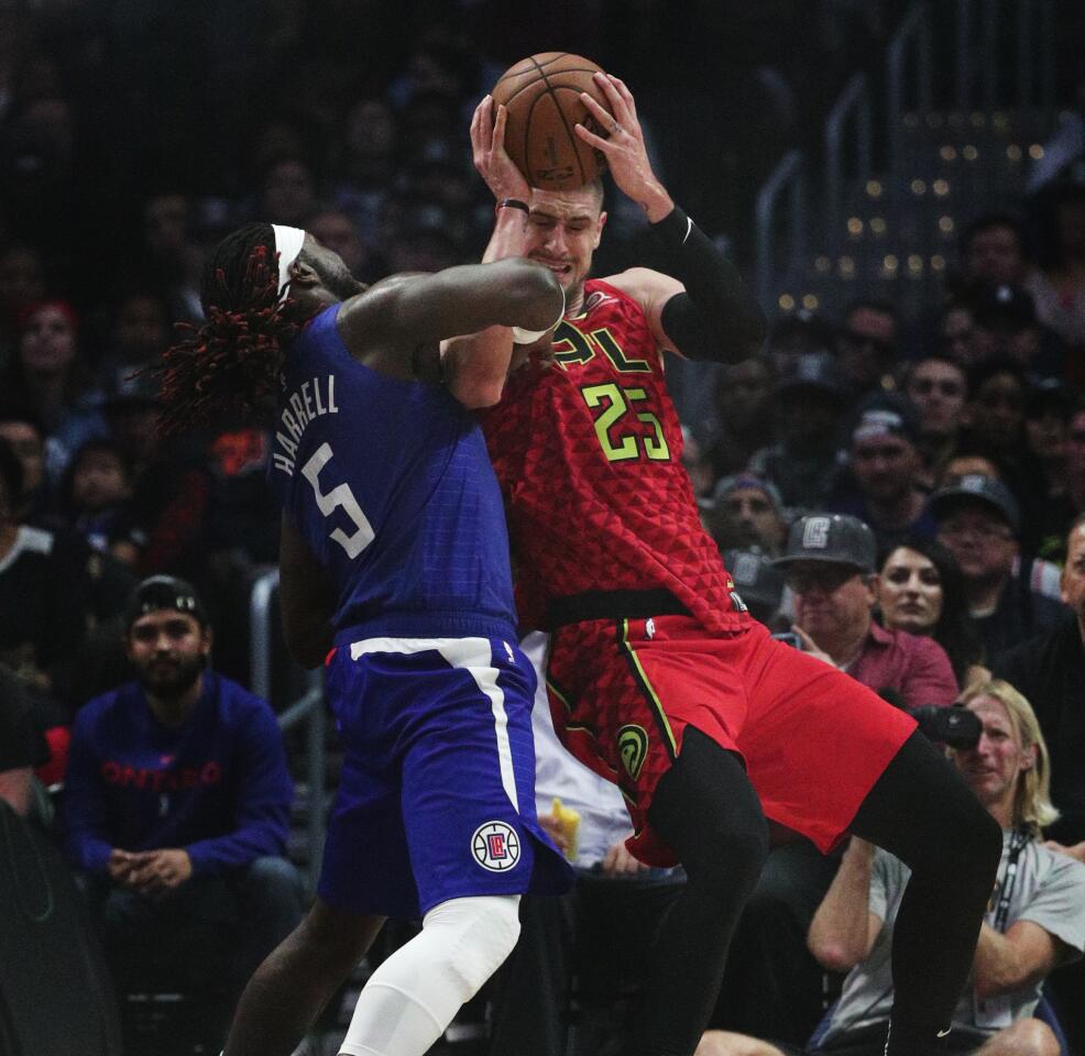 Clippers forward Montrezl Harrell plays tight defense on Atlanta Hawks center Alex Len.