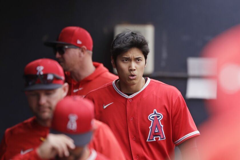 Los Angeles Angels' Shohei Ohtani walks in the dugout after grounding out against the Seattle Mariners during a spring training baseball game Tuesday, March 10, 2020, in Peoria, Ariz. (AP Photo/Elaine Thompson)