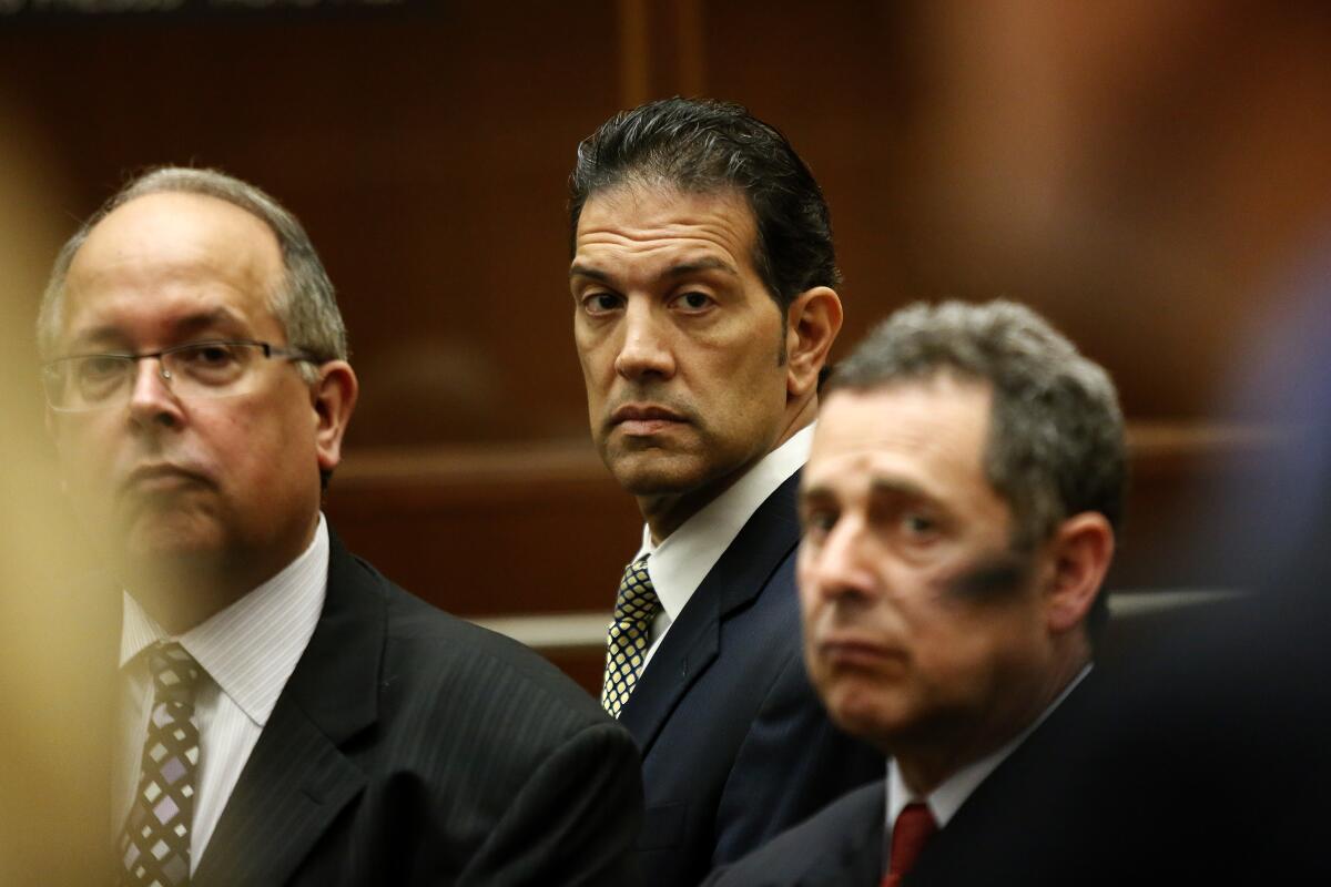 A man appears with his attorneys in court.