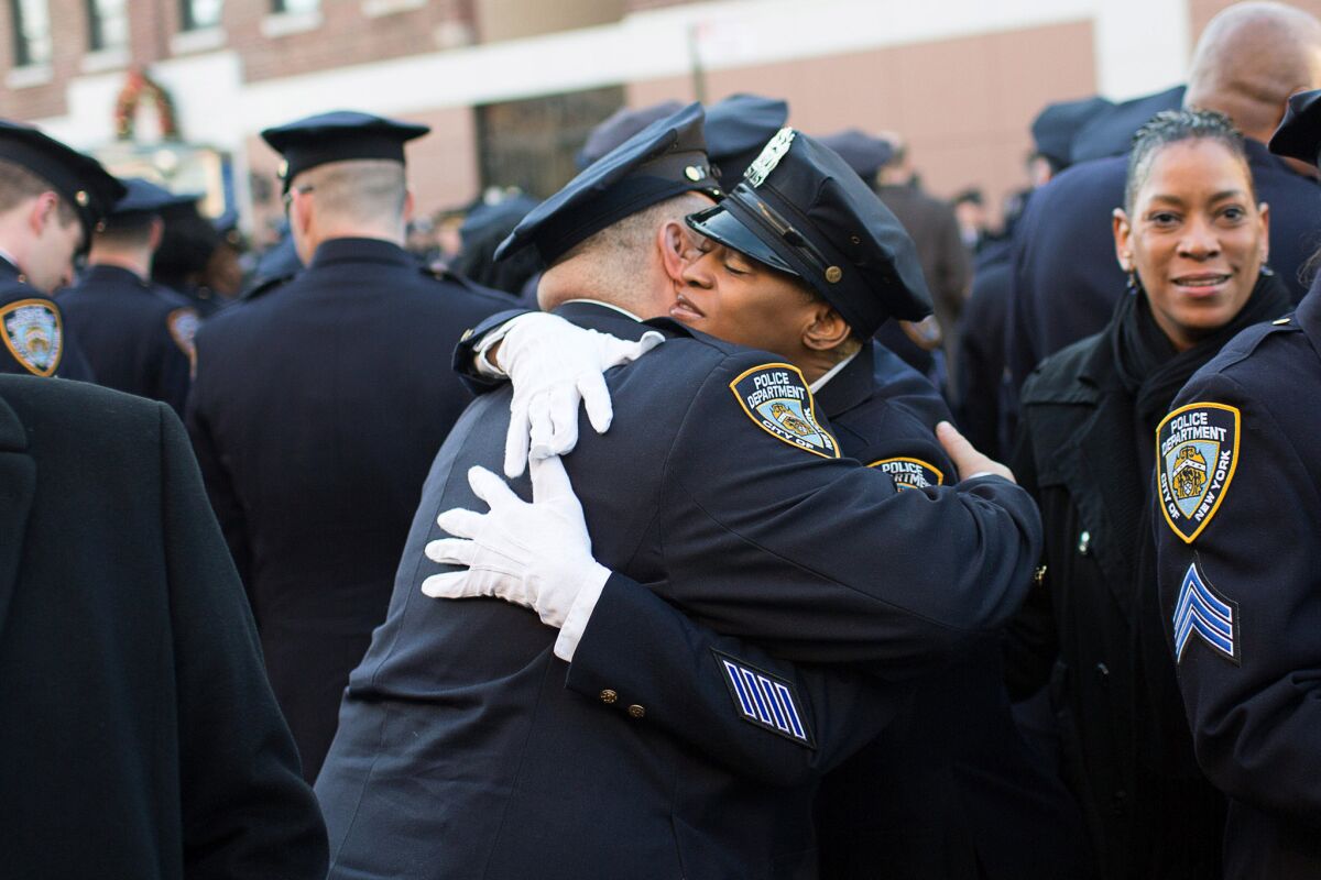 New York Police Department officers embrace before the funeral of slain officer Rafael Ramos on Dec. 27.