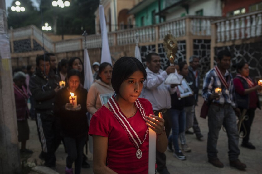 Residents hold a candlelight vigil to pray for three local teenagers in hopes they are not among the 53 migrants who died in a stifling, abandoned trailer in Texas, in San Marcos Atexquilapan, Veracruz state, Mexico, late Thursday, June 30, 2022. One of the three teens, Misael, was later confirmed to have perished in the trailer while the fate of Jair and Yovani remained unknown. (AP Photo/Felix Marquez)