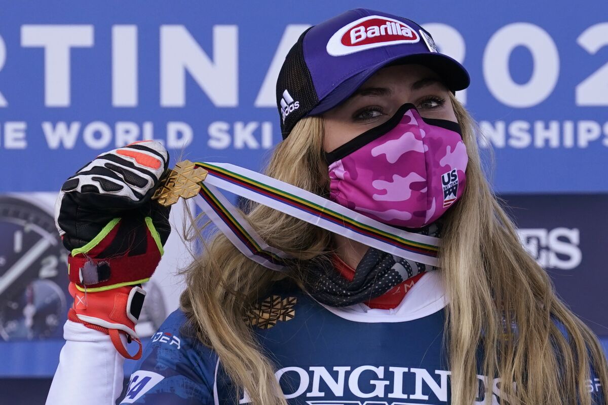 Mikaela Shiffrin holds up the gold medal on a ribbon around her neck.