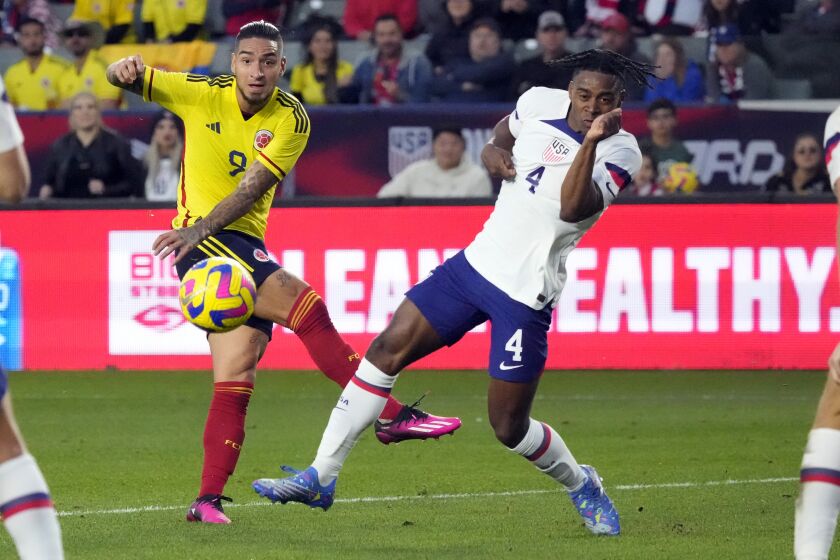 Colombia's Cristian Arango, left, takes a shot on goal next to United States' DeJuan Jones during the first half of an international friendly soccer match Saturday, Jan. 28, 2023, in Carson, Calif. (AP Photo/Marcio Jose Sanchez)