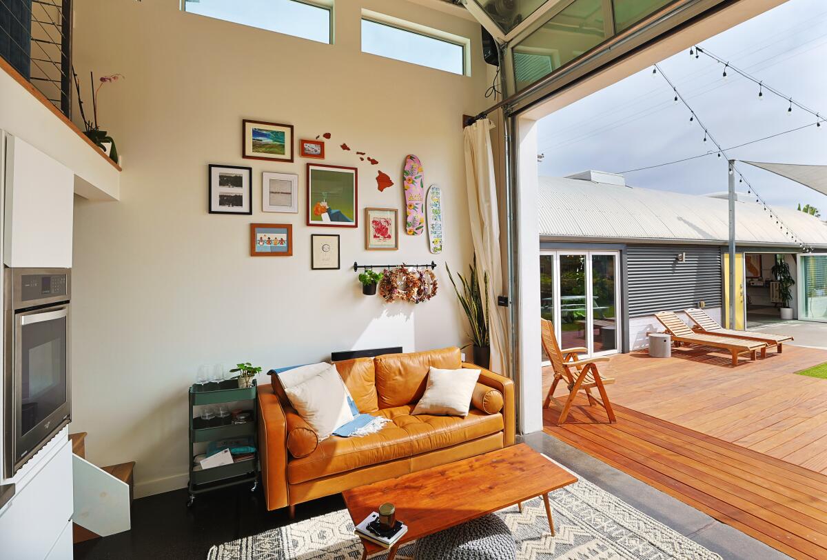 The 350-square-foot casita (left) has 15-foot ceilings and opens to the courtyard via a roll-up garage door.
