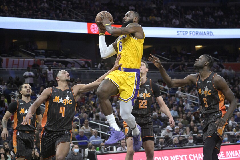 Los Angeles Lakers forward LeBron James (6) goes up to shoot between Orlando Magic guard Cole Anthony, left, guard Jalen Suggs (4), forward Franz Wagner (22) and center Mo Bamba (5) during the first half of an NBA basketball game, Friday, Jan. 21, 2022, in Orlando, Fla. (AP Photo/Phelan M. Ebenhack)