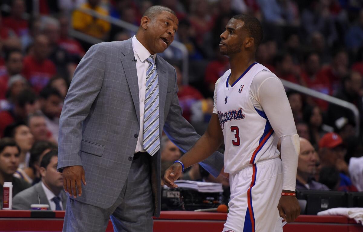 Clippers Coach Doc Rivers, left, speaks with point guard Chris Paul during Game 1 of the Western Conference quarterfinals against the Golden State Warriors on Saturday.