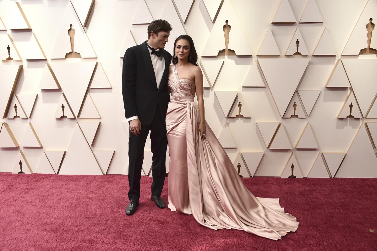 Ashton Kutcher, izquierda, y Mila Kunis llegan a los Oscar el 27 de marzo de 2022 en el Teatro Dolby en Los Angeles.