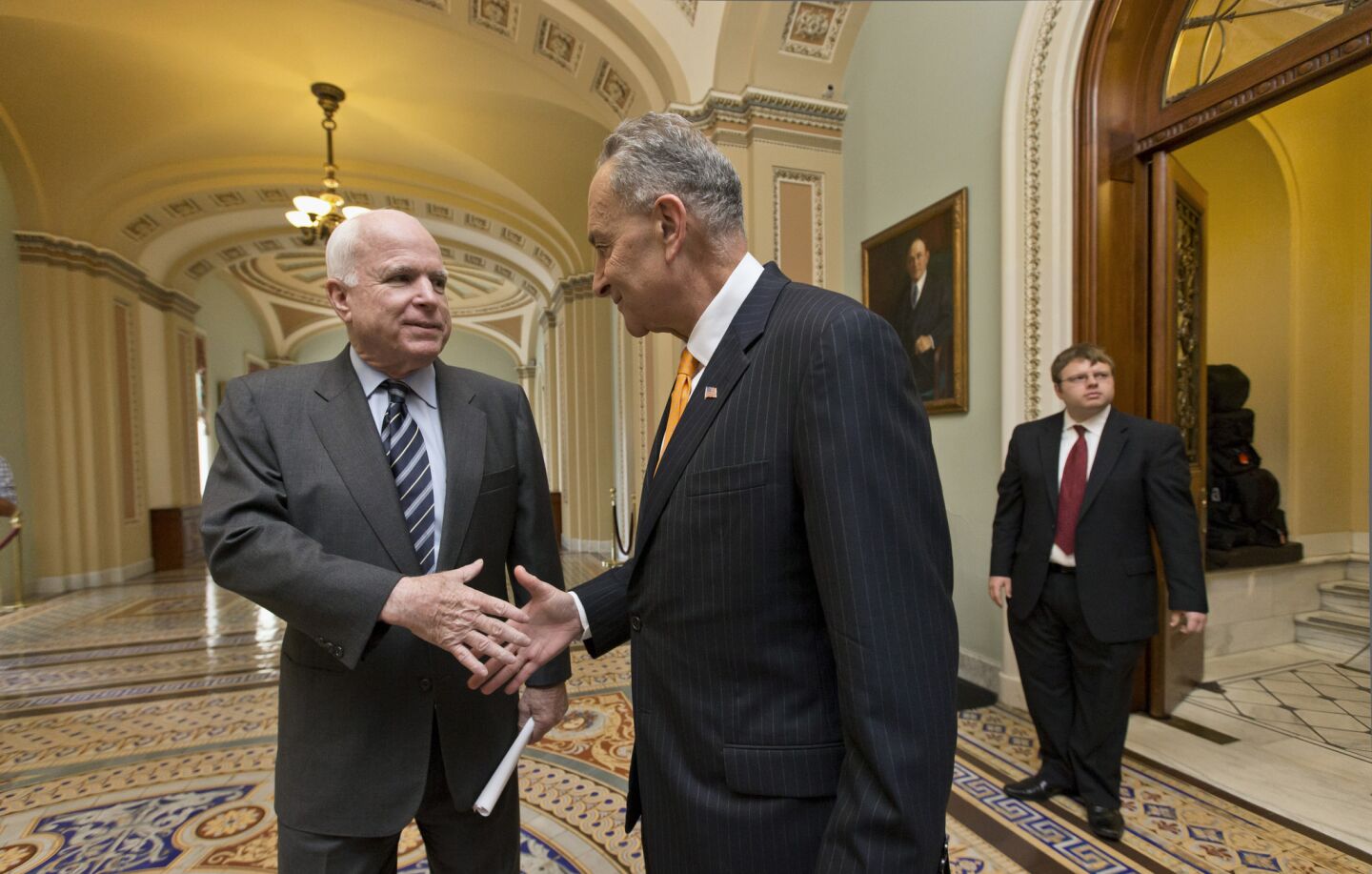 Sen. John McCain (R-Ariz.), left, and Sen. Charles Schumer (D-N.Y.), members of the bipartisan "Gang of Eight" who crafted the immigration bill, shake hands on Capitol Hill in Washington.