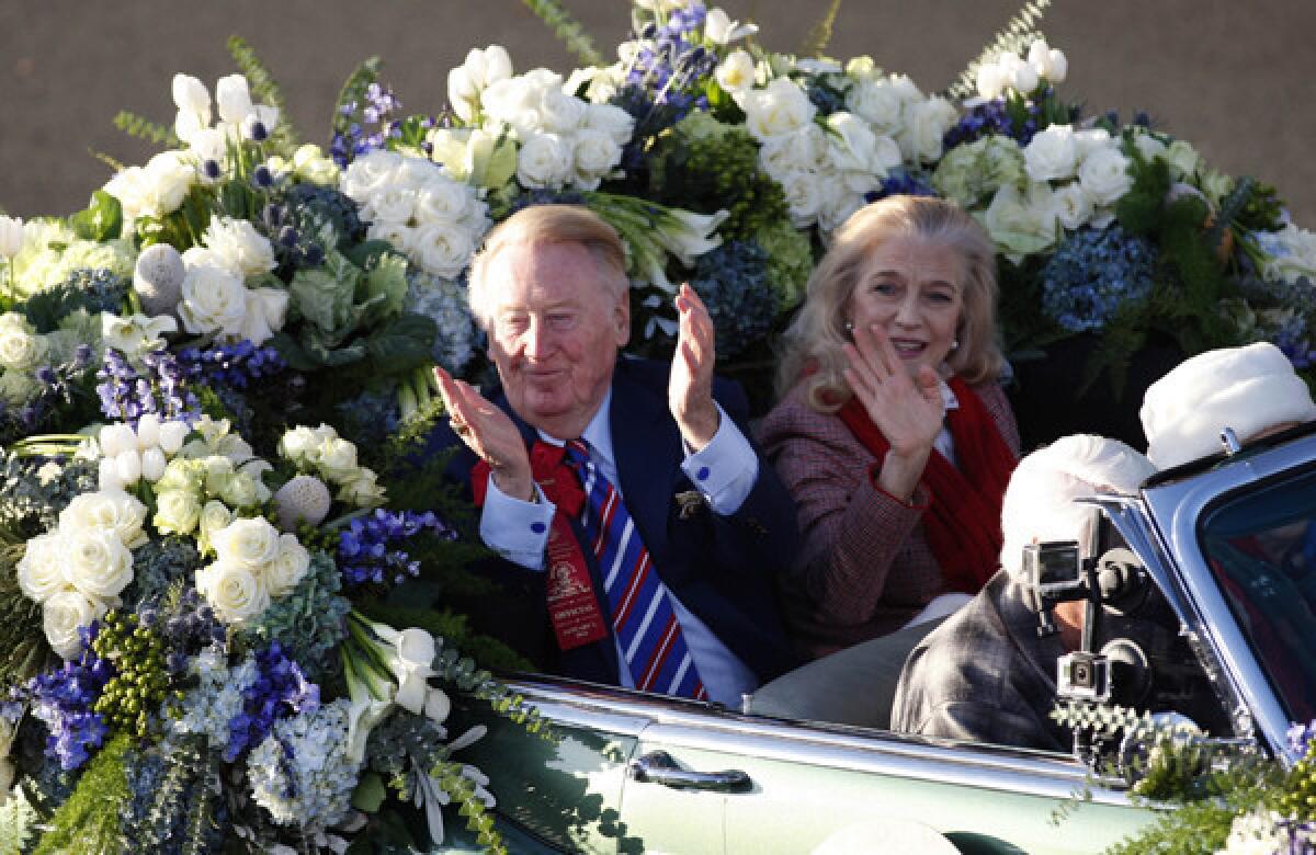 Dodgers broadcaster Vin Scully and his wife Sandi acknowledge the crowd while riding in a car during Wednesday's Rose Parade. Scully says the honor of serving as the parade's grand marshal has been a "marvelous treat" for him.