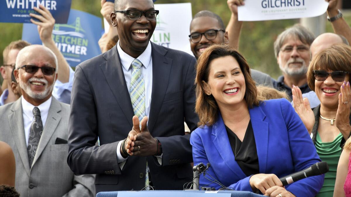 Democratic candidate for governor Gretchen Whitmer, right, announces her running mate is Garlin Gilchrist II, center, during an event in downtown Lansing, Mich., on Aug 20.