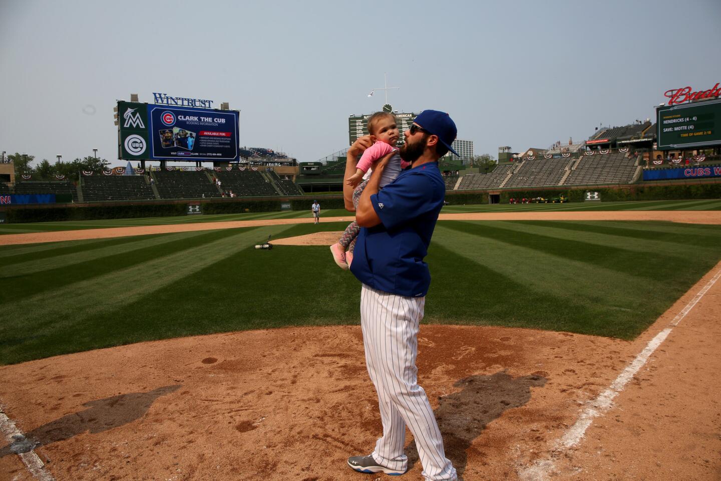 Jake Arrieta runs the bases after the game with his daughter Palmer.