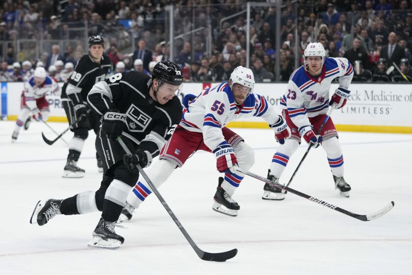 Los Angeles Kings' Jaret Anderson-Dolan moves the puck past New York Rangers' Ryan Lindgren (55) during the second period of an NHL hockey game, Tuesday, Nov. 22, 2022, in Los Angeles. (AP Photo/Jae C. Hong)