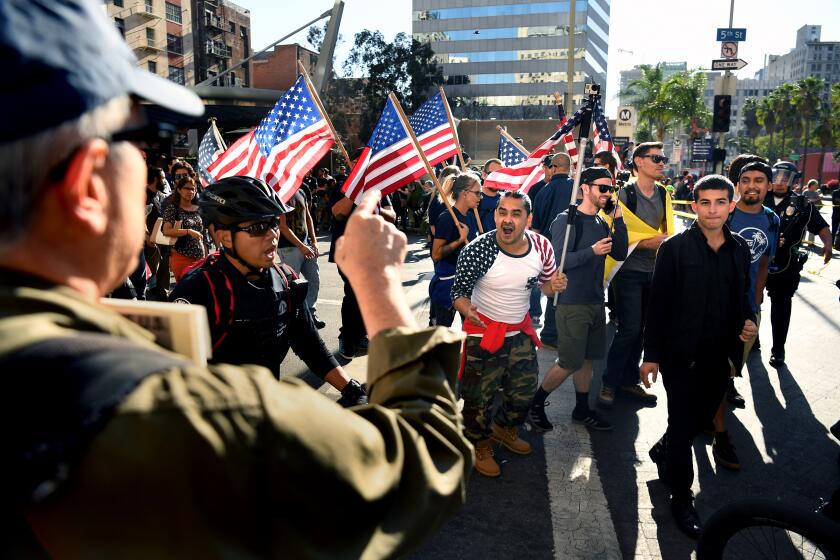 LOS ANGELES, CALIFORNIA NOVEMBER 4, 2017-Trump supporters march as an anti-Trump protestors yell from the sidewalk in Downtown Los Angeles Saturday. (Wally Skalij/Los Angeles Times)