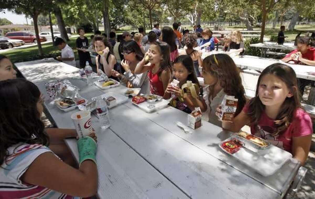 About 50 children enjoy a hot lunch from the summer parks program in 2010. Burbank has cut the program this summer.