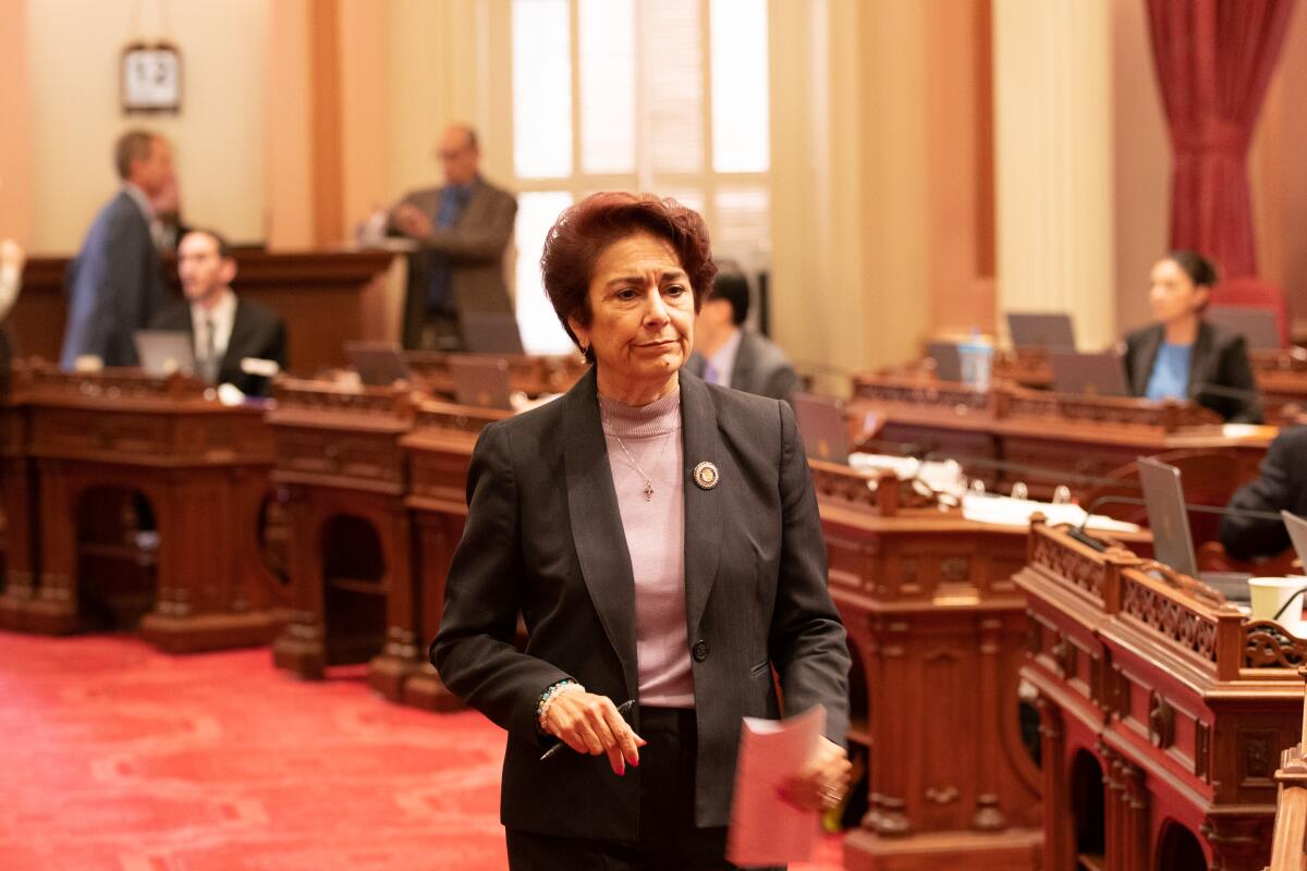 Anna Caballero walks across the floor of the California Senate.