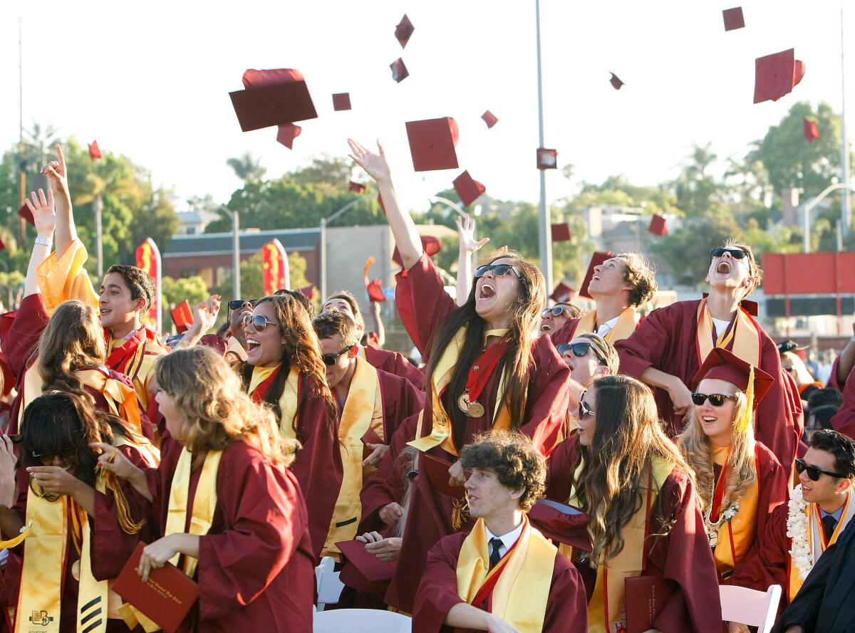 Graduates at Woodrow Wilson Classical High School in Long Beach toss their caps into the air at the end of their commencement ceremony in June 2013.