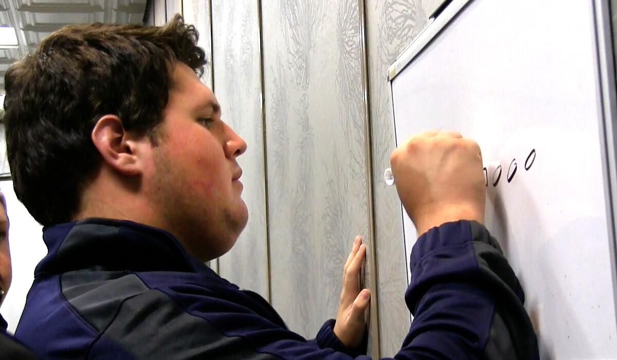 St. John Bosco lineman Matt Katnik draws a formation on an eraser board.