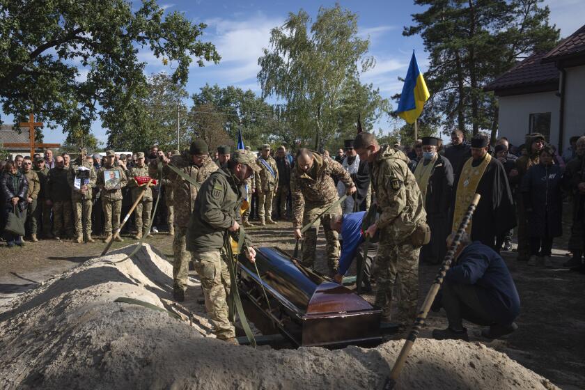 People attend a funeral ceremony for lieutenant colonel Vitali Baranov, commander of the 206th battalion of the Ukrainian army territorial defence, in Katiuzhanka close to Kyiv, Ukraine, Wednesday, Oct. 11, 2023. (AP Photo/Efrem Lukatsky)