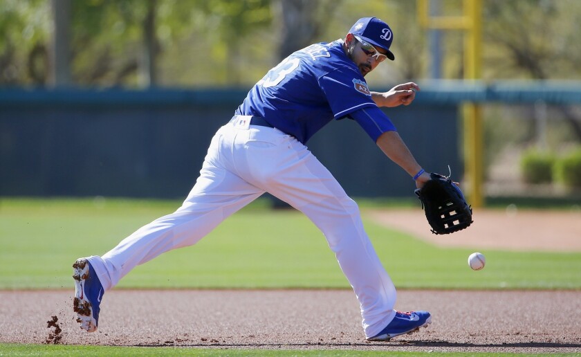 Adrian Gonzalez reaches out to snag a grounder during a workout Friday.