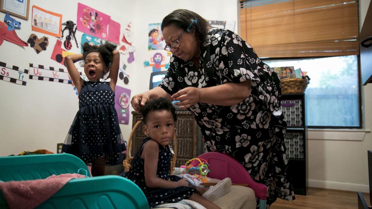 Journii Perkins yawns as her grandmother Cheryl Givens-Perkins brushes sister Camille's hair as they get ready for church.