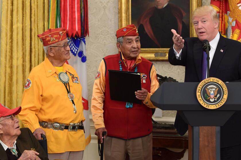 President Donald Trump, right, speaks during a meeting with Navajo Code Talkers including Fleming Begaye Sr., seated left, Thomas Begay, second from left, and Peter MacDonald, second from right, in the Oval Office of the White House in Washington, Monday, Nov. 27, 2017. (AP Photo/Susan Walsh)