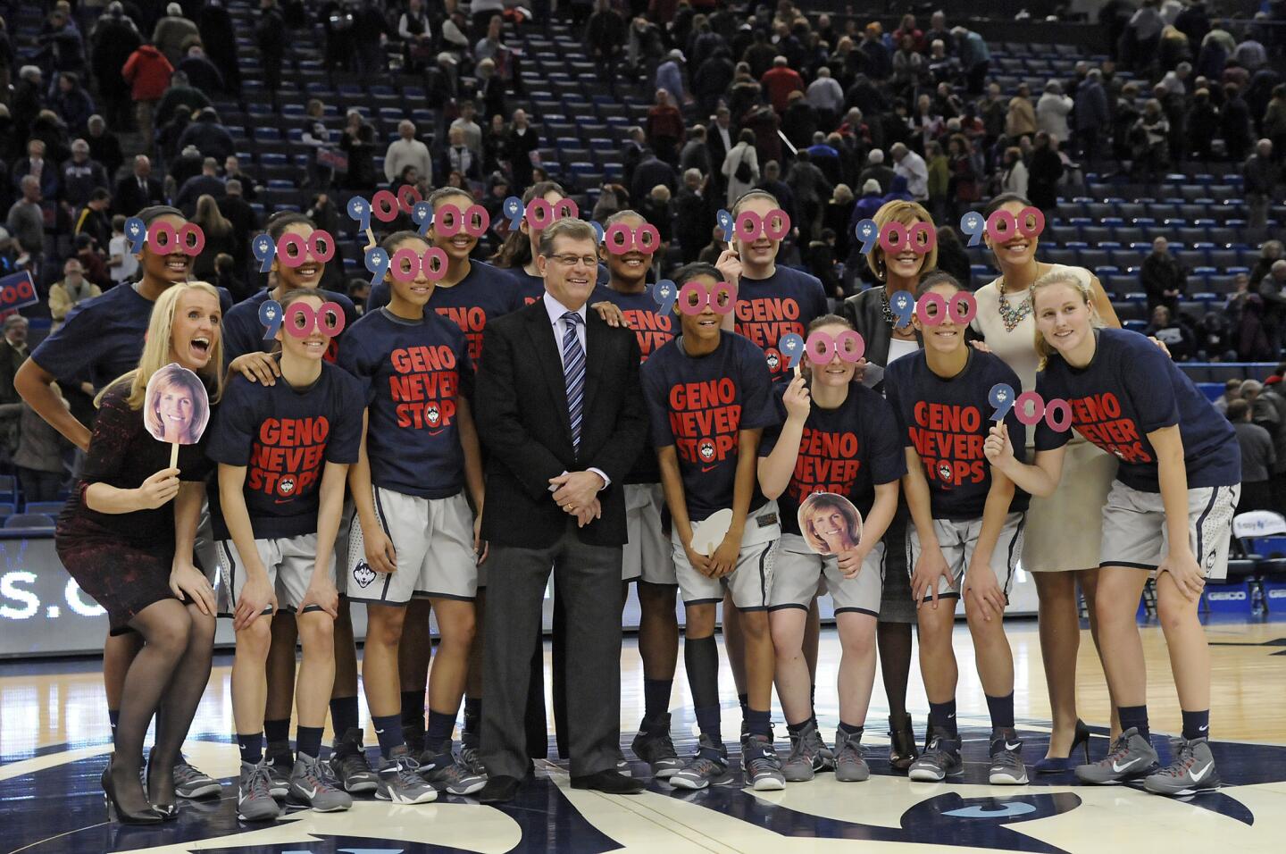 Connecticut Huskies head coach Geno Auriemma stands with his players and coaches after winning his 900th game, 96-36, against Cincinnati at the XL Center Tuesday night.