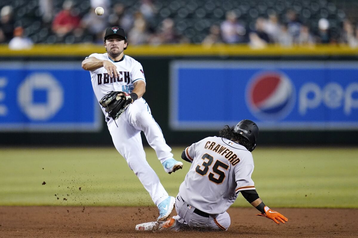 Arizona Diamondbacks second baseman Buddy Kennedy throws to first base for a double play after forcing out San Francisco Giants' Brandon Crawford (35) at second base during the third inning of a baseball game Tuesday, July 5, 2022, in Phoenix. (AP Photo/Ross D. Franklin)