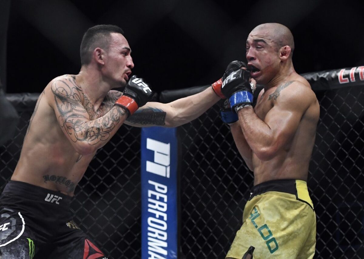 Max Holloway hits Jose Aldo with a left hand during their featherweight title fight at UFC 218.