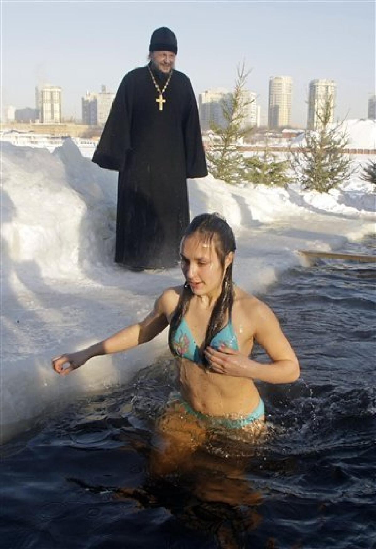 A girl emerges from cold water after plunging into icy pond to mark the upcoming Epiphany in the northwestern Moscow, Monday, Jan. 18, 2010. Thousands of Russian Orthodox Church followers plunged Monday into icy rivers and ponds across the country to mark the upcoming Epiphany, cleansing themselves with water deemed holy for the day. Water that is blessed by a cleric on Epiphany is considered holy and pure until next year's celebration, and is believed to have special powers of protection and healing. The Russian Orthodox Church follows the old Julian calendar, according to which Epiphany falls on Jan. 19. Moscow temperatures on Monday morning dropped to -20 C (-4 F). (AP Photo/Mikhail Metzel) — AP