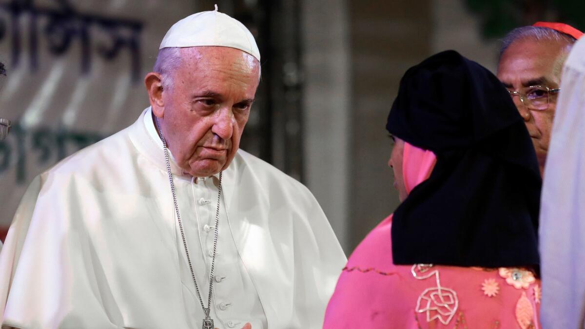 Pope Francis meets Rohingya Muslim refugees from Myanmar during an interfaith and ecumenical meeting for peace in the garden of the archbishop's residence, in Dhaka, Bangladesh, on Friday.