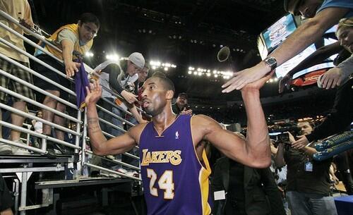Lakers guard Kobe Bryant slaps hands with fans as he comes off the court after the Lakers' 111-105 win.