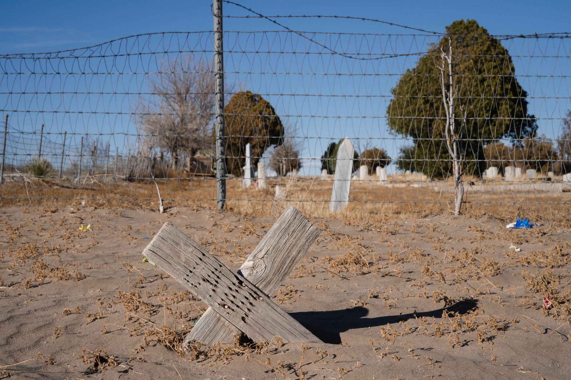 A barbed wire fence in a cemetery.